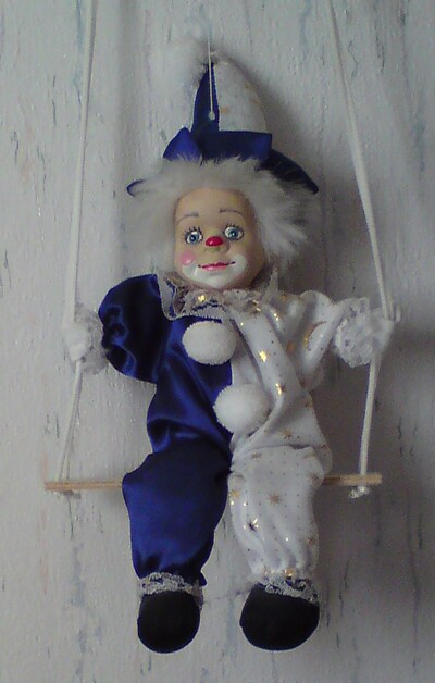 Clown auf Schaukel in blau weiss.