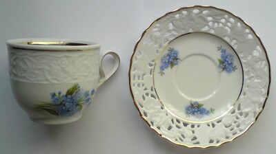 Tasse und Untersetzer mit Goldrand - Motiv blaue Pflanze.